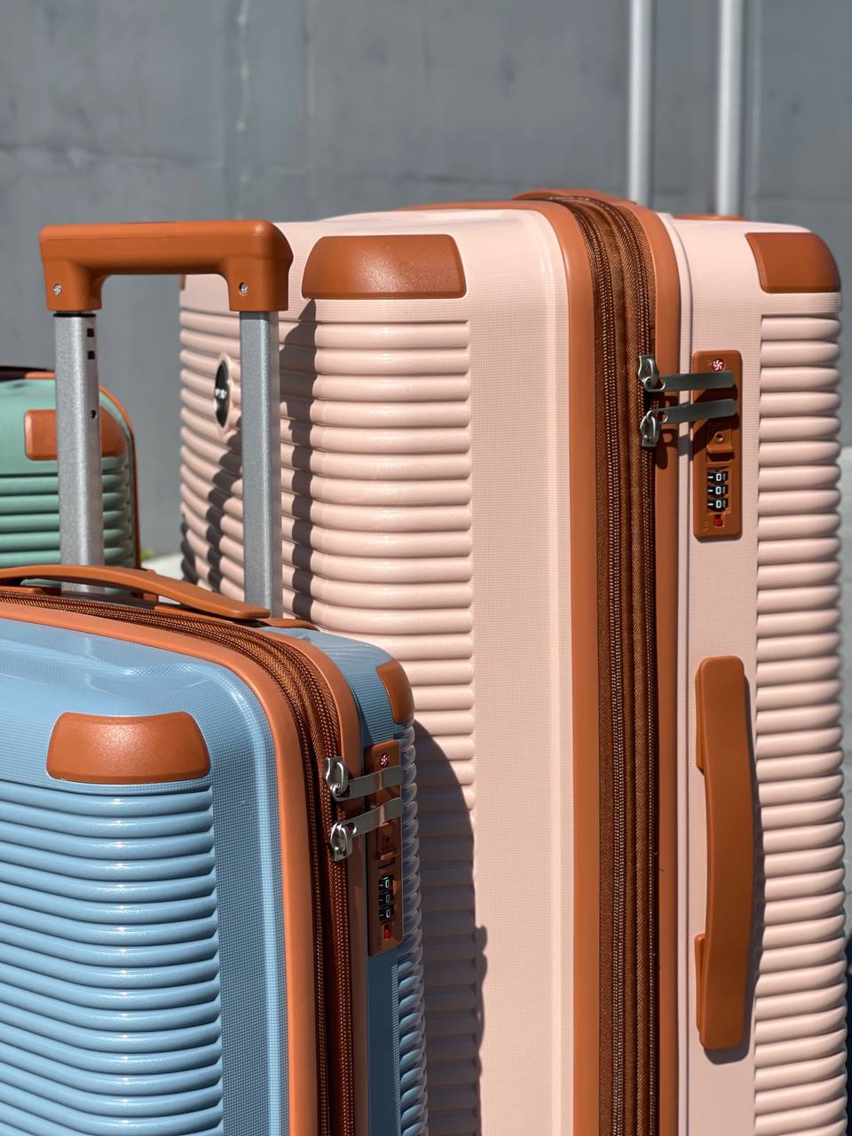 Чемодан Mybag Combo персиковый боковой вид рядом с маленьким голубым чемоданом с поднятыми выдвижными ручками